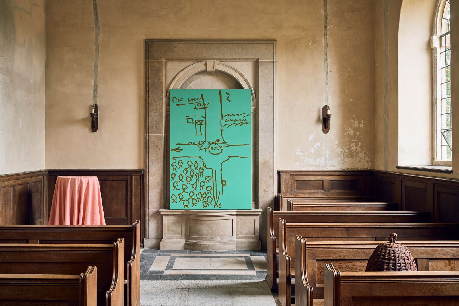 Green painted map-drawing propped in a stone niche of a wood-panelled chapel